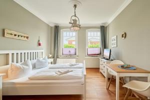 a bedroom with a bed and a desk with a computer at Haus Sonnenhof Sonnenhof 10 - Joni in Kellenhusen