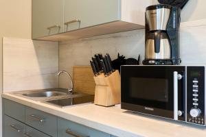a kitchen counter with a microwave and a sink at Haus Sonnenhof Sonnenhof 10 - Joni in Kellenhusen