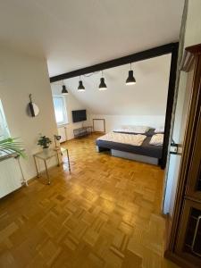 a bedroom with a bed and a wooden floor at Appartement zur Mühle in Altenberge +14 photos