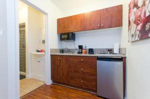 a kitchen with wooden cabinets and a stainless steel dishwasher at Cute Studio in the Heart of Hollywood in Los Angeles