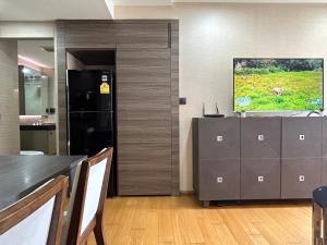 cocina con nevera negra y TV en Klass Langsuan Condo, en Bangkok 26 fotos más