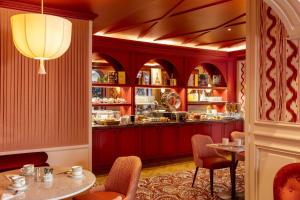 a restaurant with red walls and a table and chairs at Au Manoir Saint Germain in Paris