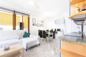 ein Wohnzimmer mit einer weißen Couch und einer Küche in der Unterkunft Home2Book Paradise Playa Las Vistas, Terrace in Los Cristianos