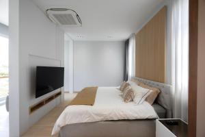 una camera da letto con un letto e una TV a schermo piatto di The Haven Boutique Villa, 5 min to Kad Farang a Ban Yang Pa Kha Altre 24 foto
