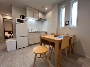 Una cocina y un comedor con mesa y sillas. en PRISM Inn Tateishi, en Tokio