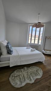 a bedroom with a white bed and a window at Havre de sérénité coeur de Dijon in Dijon