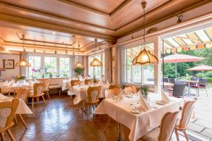 a restaurant with white tables and chairs and windows at Hotel & Restaurant Gasthof Belchenblick in Münstertal