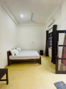 a white room with a bed and a window at Blue Horizon in Ahangama