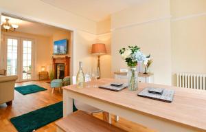 Un comedor con una mesa con flores. en Castle Square Cottage - Beachside Retreat, en Mumbles 9 fotos más