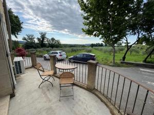 eine Terrasse mit Tisch und Stühlen auf einem Balkon in der Unterkunft Maison de charme, pleine nature in Saint-Côme-et-Maruéjols