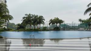 une grande piscine avec des palmiers en arrière-plan dans l'établissement Danga Bay Family CrestJoy 3BR 6pax Balcony by Our Stay, à Johor Bahru