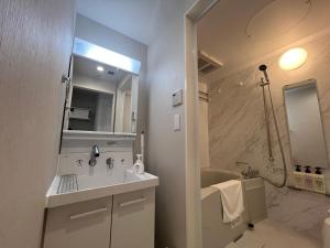 a white bathroom with a sink and a tub at PRISM Inn Tateishi in Tokyo +18 photos