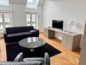 a living room with a couch and a tv at Klimatisierte Luxus-Dachterrassenwohnung im Zentrum in Sankt Pölten