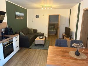 a living room with a couch and a table at Bayerwaldapartment in Viechtach +4 photos