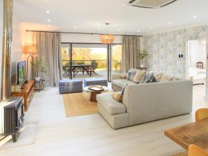 a living room with a couch and a tv at Crane Song Cottage-Solar Power in Himeville