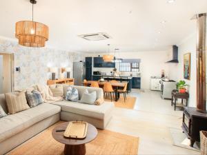 a living room with a couch and a table at Crane Song Cottage-Solar Power in Himeville