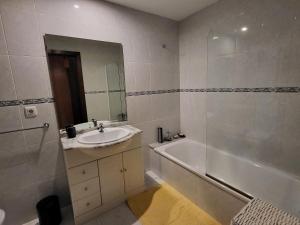 een badkamer met een bad en een wastafel en een ligbad bij Apartemento Cerveira in Vila Nova de Cerveira +7 foto's