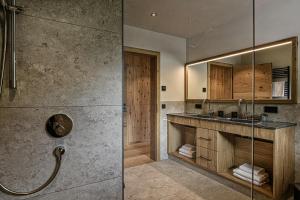 a bathroom with a shower and a sink and a mirror at Naturhof eibl in Grossarl +77 photos