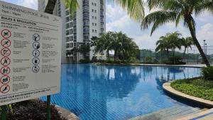 a sign next to a swimming pool at a building at Danga Bay Seaview Escape 3BR 8pax Balcony by Our Stay in Johor Bahru