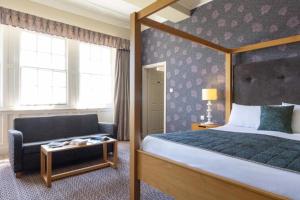 a bedroom with a bed and a chair in a room at The Portpatrick Hotel by Compass Hospitality in Portpatrick +86 photos