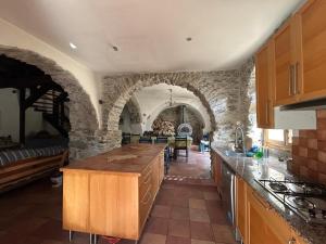 a kitchen with stone walls and a wooden counter top at Molino di Carpenosa in Molini di Triora +3 photos