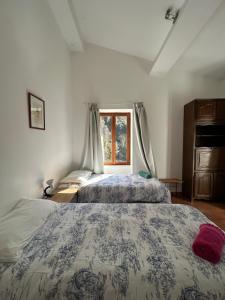 a bedroom with two beds and a window at Molino di Carpenosa in Molini di Triora