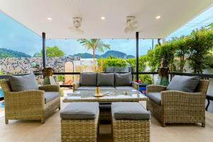 a patio with wicker furniture and a table and chairs at Arabella Ao Nang Private Pool Villa in Ao Nang Beach