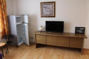 a room with a desk with a television and a refrigerator at Möblierte 2-Raum Wohnung in Ohrdruf OT Crawinkel Thüringen Wald in Ohrdruf