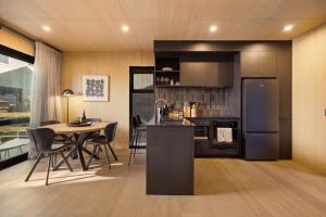 une cuisine et une salle à manger avec une table et un réfrigérateur dans l'établissement Raua Luxury Queenstown Villa, à Queenstown