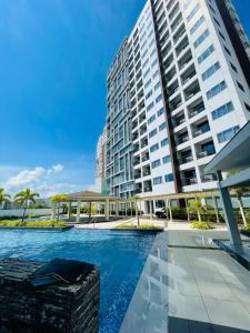 a swimming pool in front of a tall building at The Mactan Beach Condo Staycation in Punta Engaño