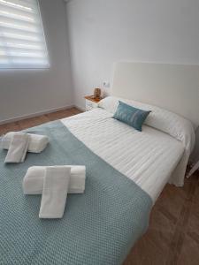 a bedroom with a large white bed with towels on it at Mar azul in Puerto de Mazarrón