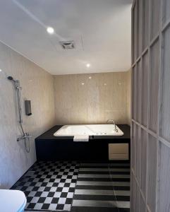 un baño con bañera y lavabo en Fairy Tale City Motel, en Hualien City 79 fotos más