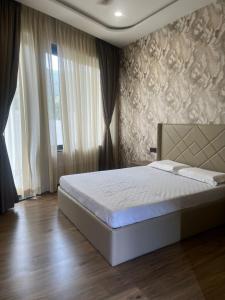 a bedroom with a bed and a large window at Nuwara Eliya Karjat - 5BHK Villa in Karjat