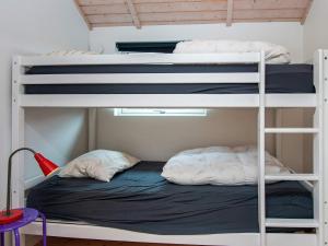 two bunk beds in a small room with a bed at Bright Family Cottage by Kelstrup Beach in Kelstrup Strand +14 photos