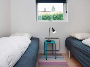 a bedroom with two beds and a lamp on a table at Bright Family Cottage by Kelstrup Beach in Kelstrup Strand