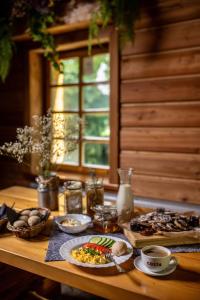 Una mesa de madera con comida y bebidas encima. en Gospoda Dębowiec520, en Bielsko-Biala