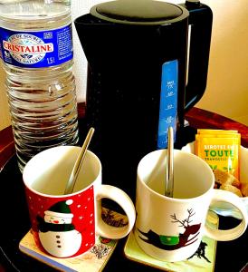 two coffee mugs with snowmans on them on a table at CHAMBRE SUITE - Entrée INDÉPENDANTE - Wifi Tv Sport - Chez L habitant in Thiel-sur-Acolin