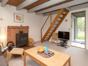 a living room with a wood stove and a staircase at 5 person holiday home in Ebeltoft-By Traum in Øksenmølle