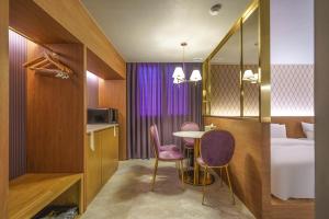 a hotel room with a table and chairs and a bed at Yongin IPPDA Petite in Yongin