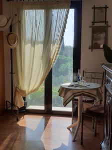a dining room with a table and a large window at Corfu Cosy Apartment by the Nature in Kato Korakiana
