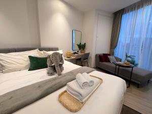 a bedroom with a bed with towels and an elephant on it at Edge central Pattaya by kansiree in Pattaya