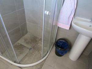 Una ducha con puerta de cristal junto al lavabo en Island View Room, en Mossel Bay 7 fotos más