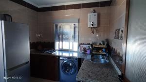 a kitchen with a washing machine and a sink at Belyounech ABD in Belyounech 