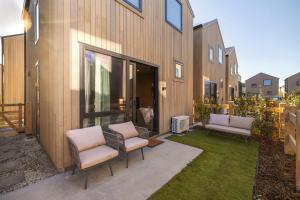 a backyard with two chairs and a building at Kawarau Villa, Queenstown in Queenstown