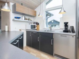 a kitchen with black and silver cabinets and a sink at 10 person holiday home in Harboøre-By Traum in Harboør