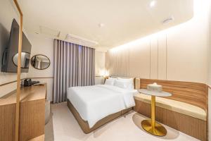 a hotel room with a bed and a table at Yongin IPPDA Petite in Yongin +68 photos