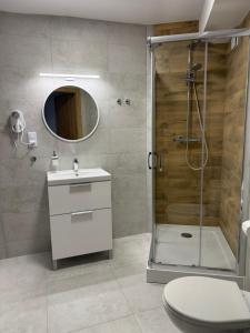 a bathroom with a shower and a toilet and a sink at Ośrodek Jantar Rewita in Hel +54 photos