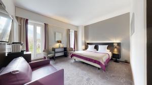 a hotel room with a bed and a couch at Grand Hotel des Bains in Lavey-les-Bains
