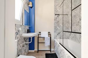a bathroom with blue walls and a sink and a tub at Refreshed apartment with private garden in Almada +46 photos