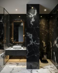 a black bathroom with a sink and a mirror at Hotel Airport View at Delhi Airport by Global Group in New Delhi